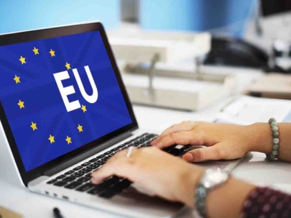 Female blogger with laptop recording video while sitting at offi